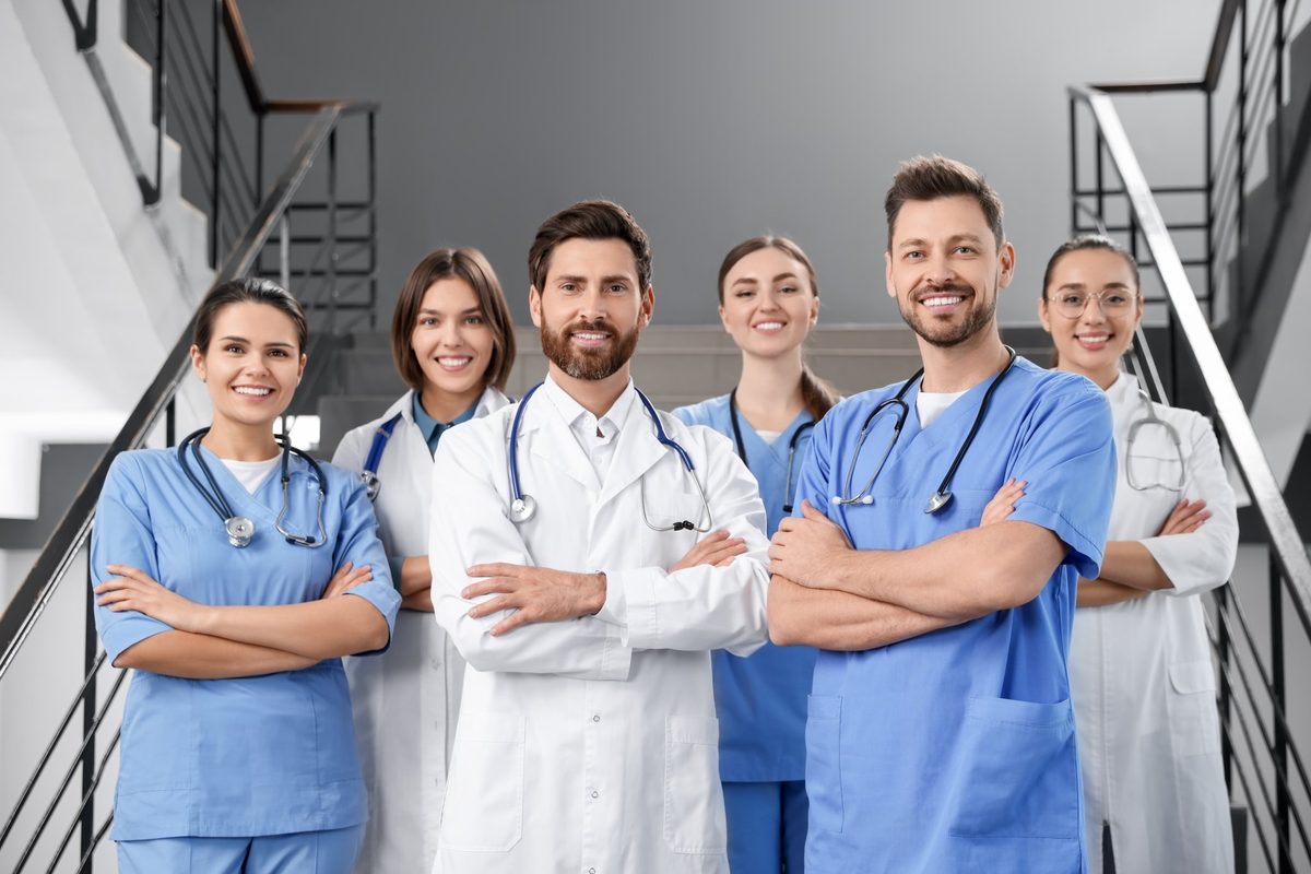 Team of doctors and nurses in scrubs and white coats